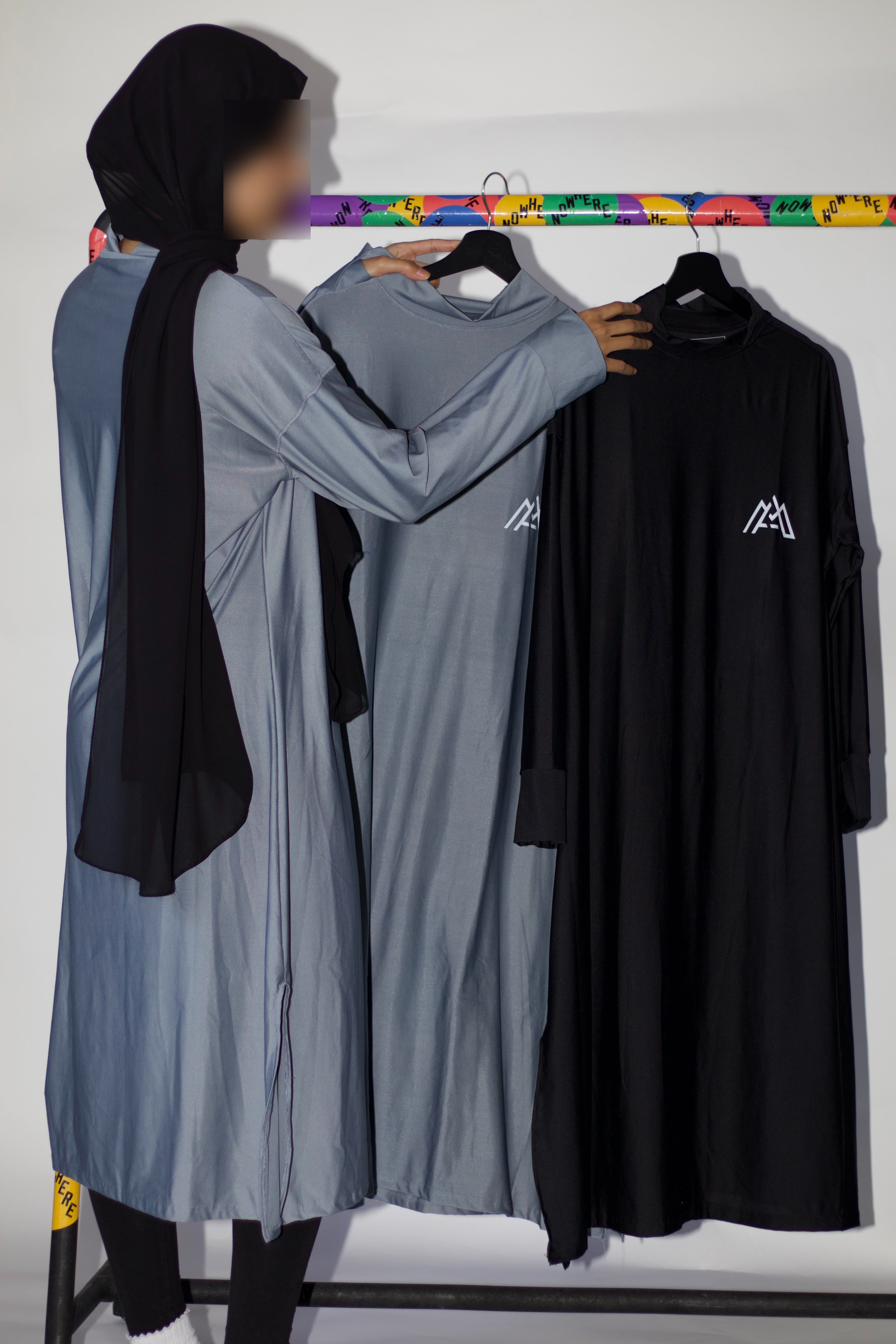 Muslim Woman Hanging Sports Abayas on Clothing Rack